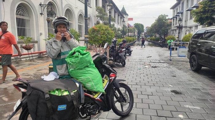 Edi Tasliman warga Langensari Barat, Ungaran Barat, Kabupaten Semarang  kesulitan ambil ikan bandeng di Pasar Kobong akibat banjir Semarang, Kamis (14/3/2024).