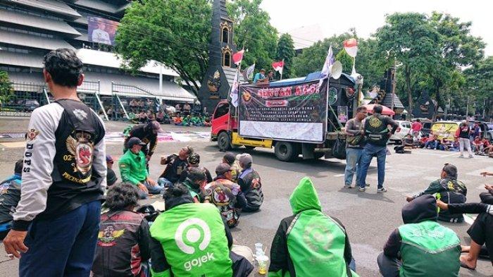 GELAR AKSI - Sejumlah driver Ojol dari beberapa daerah di Jawa Tengah menggelar aksi di depan Kantor Gubernur Jawa Tengah, Selasa (20/5/2025). Dalam aksi tersebut massa menuntut agar ada payung hukum untuk transportasi online baik roda dua maupun empat serta menghilangkan tarif murah dan menyamakan tarif. (TRIBUN JATENG/BUDI SUSANTO)