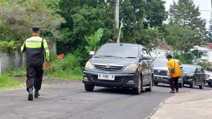 Tim gabungan mendorong dan mengganjal ban kendaraan para wisatawan yang tidak kuat menanjak di Simpang Tiga Hotel BIP Tawangmangu Kabupaten Karanganyar, Minggu (31/12/2023).