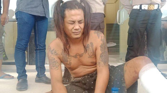 Pelaku bernama Joko Umbaran telanjang dada dengan luka tembak di kakinya saat dibawa pihak kepolisian di Mapolres Blora