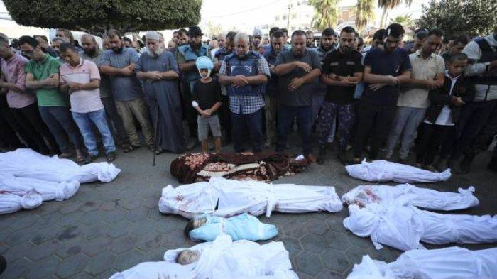 Jurnalis Al Jazeera, Wael Al-Dahdouh (tengah), mengimami salat jenazah sebelum pemakaman istri, dua anak, dan cucunya di luar Rumah Sakit Syuhada Al-Aqsa, Deir Al-Balah, selatan Jalur Gaza, Kamis (26/10/2023). Keluarga Wael terbunuh dalam serangan udara Israel ke kamp pengungsian Nuisserat, Rabu (25/10) malam waktu setempat.