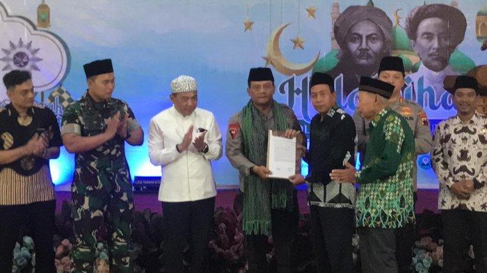 Rais Syuriah PCNU Kabupaten Jepara Kiai Khayatun Abdullah Hadziq didampingi Ketua PD Muhammadiyah Jepara Kiai Fakhrurrozi menyerahkan berkas berisi Komitmen dan Seruan Bersama NU - Muhammadiyah untuk Pilkada berkualitas di sela-sela kegiatan halal bi halal yang digelar di Ono Joglo Resort, Minggu (12/5/2024)