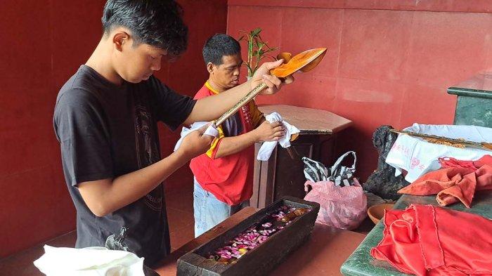 Terlihat warga saat membersihkan keris yang biasa dipajang di altar Mbah Kuncung yang dianggap sebagai salah satu leluhur aslu Banyumas di Klenteng Boen Tek Bio Banyumas, Kamis (23/1/2025).