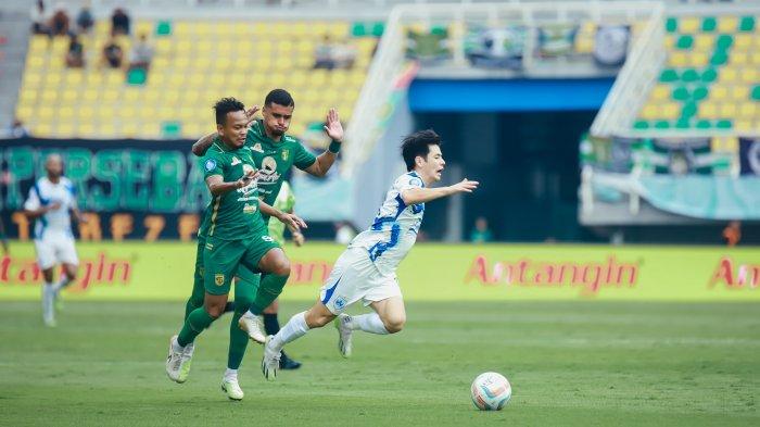 Pemain PSIS Semarang Taisei Marukawa terjatuh usai berduel dengan pemain Persebaya Surabaya Mohammad Hidayat dalam laga tunda BRI Liga 1 2023/2024 di Stadion Gelora Bung Tomo Surabaya, Selasa (30/1/2024). Pertandingan berakhir seri 1-1.