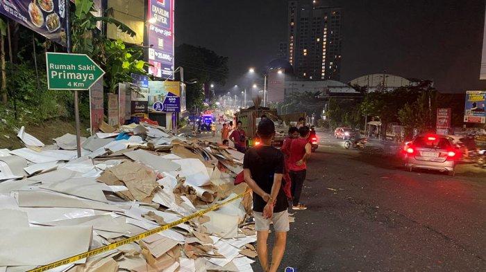 MUATAN BERCECERAN: Muatan berupa karton berceceran seusai truk yang mengangkutnya mengalami kecelakaan dan terguling di persimpangan Pasar Kambing, Jalan Dr. Wahidin, Candisari, Kota Semarang, pada Kamis (8/5/2025) malam. Warga membantu polisi mengevakuasi muatan tersebut ke pinggir jalan. (TRIBUN JATENG/REZA GUSTAV)