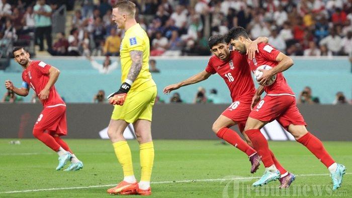 Penyerang Iran Mehdi Taremi (kanan) merayakan dengan gelandang Iran Mehdi Torabi (16) setelah dia mencetak gol melewati kiper Inggris Jordan Pickford selama pertandingan sepak bola Grup B Piala Dunia Qatar 2022 antara Inggris dan Iran di Stadion Internasional Khalifa di Doha. Senin (21/11/2022).