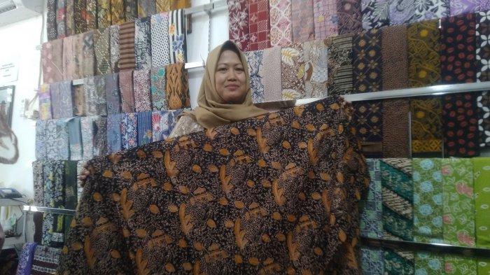 Pelaku UMKM Dasa Genta Wati memperlihatkan motif terbaru karya batiknya yang mengangkat kearifan lokal Kudus Air Tiga Rasa Rejenu, Selasa (11/7/2023).