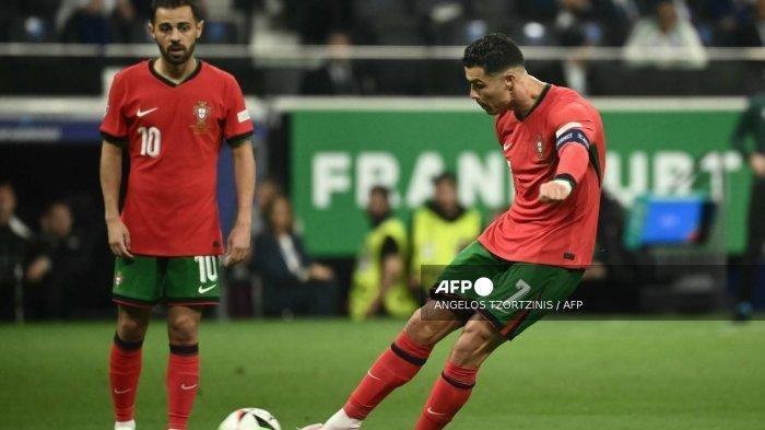 Pemain depan Portugal #07 Cristiano Ronaldo melakukan tendangan bebas saat rekan setimnya gelandang #10 Bernardo Silva menonton selama pertandingan sepak bola babak 16 besar UEFA Euro 2024 antara Portugal dan Slovenia di Frankfurt Arena di Frankfurt am Main pada tanggal 1 Juli 2024.