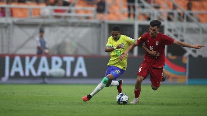 Penyerang timnas U17 Brasil, Estevao Willian (kiri), berebut bola dengan gelandang timnas U17 Iran, Abolfazl Zamani. Laga Brasil vs Iran pada matchday pertama Grup C Piala Dunia U17 2023 tersebut digelar di Jakarta International Stadium (JIS), Sabtu (11/11/2023) malam WIB.