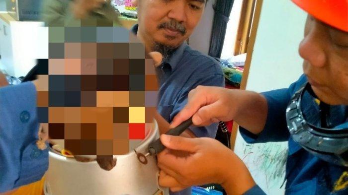 Petugas damkar Sleman memotong loyang kue yang menyangkut di leher anak Balita menggunakan gerinda mini.