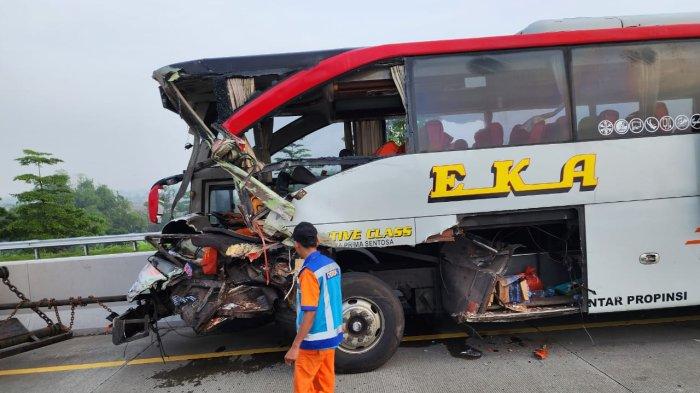 Petugas melintas di dekat bus yang mengalami kecelakaan dengan truk tronton di Jalan Tol Soker KM 515 B wilayah Kecamatan Kebakkramat Kabupaten Karanganyar pada Kamis (25/4/2024) pukul 05.00.