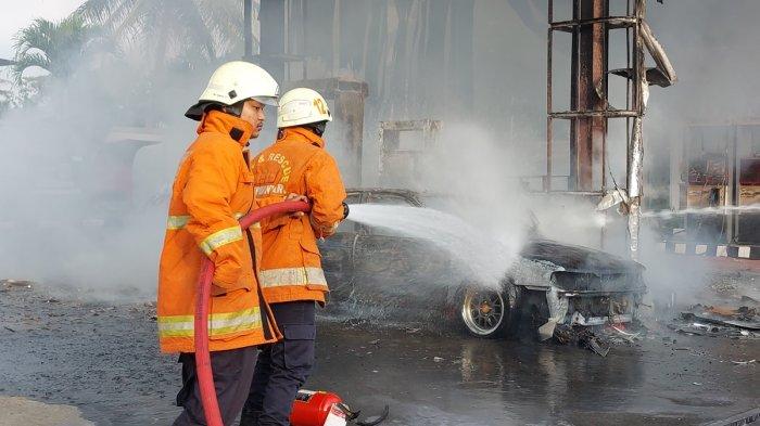 Petugas pemadam meyemprotkan air ke mobil yang hangus terbakar di SPBU wilayah Desa Dawung Kecamatan Matesih Kabupaten Karanganyar, Minggu (30/6/2024) sore.