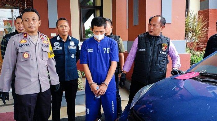 SE pelaku pencurian uang modus ganjal ATM mengenakan pakaian tahanan Polres Kudus berwarna biru dengan angka baju tahanan nomor 75 beserta mobil birunya sebagai barang bukti.