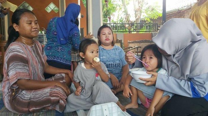 Seorang kader menyuapi balita setelah menimbang berat dan mengukur tinggi badan di Posyandu Melati Desa Ciampel, Kecamatan Kersana, Kabupaten Brebes, Kamis (19/10/2023). Di sekelilingnya orangtua ikut mendampingi.