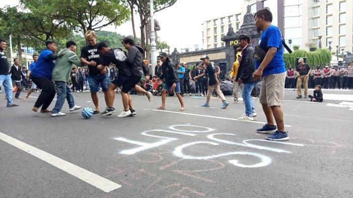 Main bola bersama antar suporter mewarnai aksi unjuk rasa memprotes tindakan represif aparat kepolisian ke suporter dan masyarakat sipil, di depan Mapolda Jateng Kota semarang, Kamis (26/12/2024) sore.