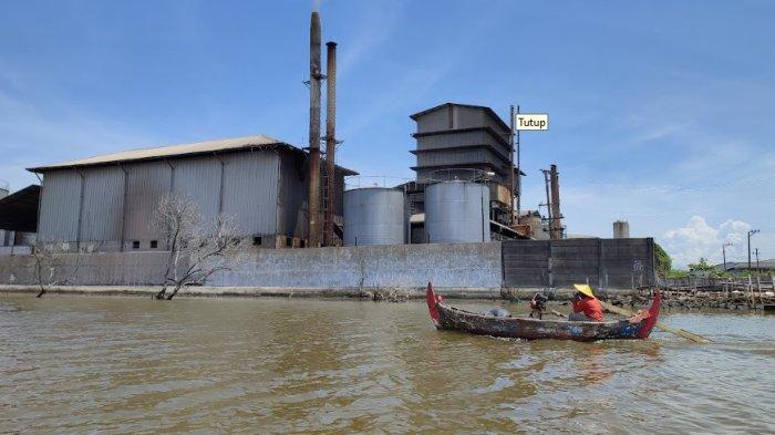 Seorang nelayan yang menambatkan perahunya di Kali Sringin hendak menuju ke laut melewati sebuah barat pabrik di sisi barat Kawasan Industri Terboyo, Genuk, Kota Semarang. Mereka kondisinya kian terdesak saat proyek TTLSD mulai dijalankan, Jumat (2/2/2024).