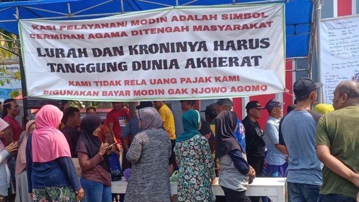 Warga Desa Pojok, Kecamatan Kawedanan, Kabupaten Magetan, Jawa Timur menggelar aksi demonstrasi di kantor desa setempat, menuntut Boby Amanda Arif Pamungkas, dicopot dari jabatannya Kepala Seksi Pelayanan atau Modin Desa.