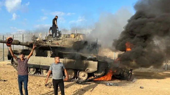 Warga Palestina bereaksi ketika kendaraan militer Israel terbakar setelah ditabrak oleh para pejuang Palestina yang menyusup ke wilayah Israel selatan, di sisi perbatasan Israel-Gaza. (Mohammed Fayq Abu Mostafa/REUTERS)