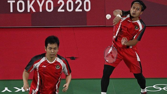 Nonton TV Online Ini Link Live Streaming Bulu Tangkis Olimpiade 2021, The Daddies Vs Malaysia. Pebulutangkis Indonesia Mohammad Ahsan (atas) melakukan pukulan di sebelah Hendra Setiawan dari Indonesia dalam pertandingan penyisihan grup bulu tangkis ganda putra melawan Aaron Chia dari Malaysia dan Soh Wooi Yik dari Malaysia selama Olimpiade Tokyo 2020 di Musashino Forest Sports Plaza di Tokyo pada 26 Juli 2021 .