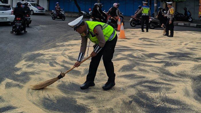 Petugas Satlantas Polres Purbalingga saat membersihkan tumpahan minyak di Jalan dekat Tugu Knalpot Purbalingga, menggunakan serbuk gergajian kayu pada Rabu (29/11/2023).