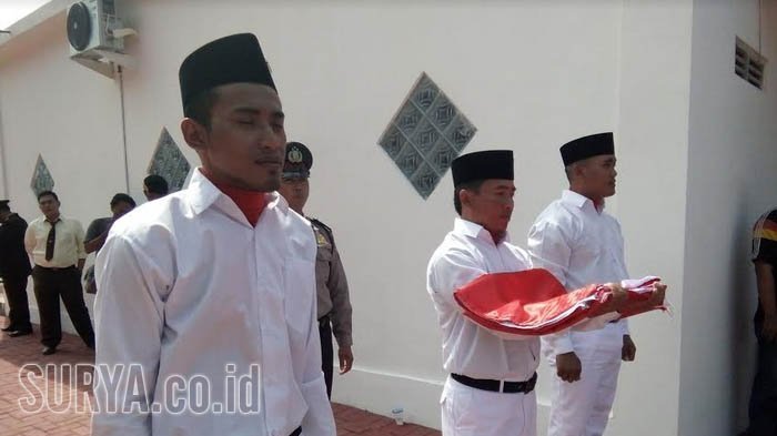 Zuli Mahendra, anak terpidana mati bom Bali satu, Amrozi (paling kiri) saat menjadi petugas pengibar bendera setelah sepuluh tahun tak sudi hormat bendera sejak orang tuanya dieksekusi mati, Kamis (17/8/2017).