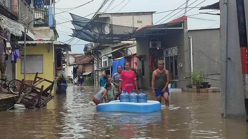Para warga Bandarharjo  saat melintasi banjir. Kawasan itu sudah alami banjir puluhan tahun. Sebelum pemilu ramai disambangi Caleg saat banjir hanya air yang datang, Semarang Utara, Kota Semarang,  Kamis (14/3/2024).