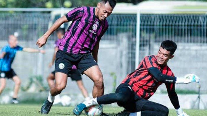 Bek Arema FC Arsyaq Gufron saat berduel dengan kiper Teguh Amiruddin dalam sesi latihan rutin Arema FC