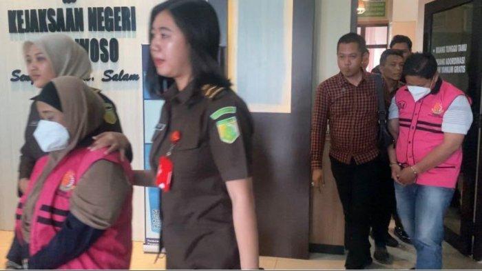 TERSANGKA KORUPSI - Dua orang tersangka inisial AK dan AS dalam dugaan kredit fiktif salah satu bank pelat merah, dengan modus pencurian data warga lanjut usia (lansia) saat digiring ke mobil tahanan dengan mengenakan rompi merah muda, di Kantor Kejari Bondowoso pada Senin (15/7/2025)