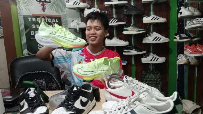 Firman menunjukkan sepatu jualan miliknya di toko kecil rumahnya, Minggu (10/11/2024)