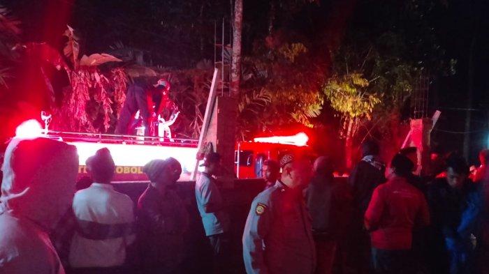 TERBAKAR : Anggota Polsek Krucil saat berada di lokasi kebakaran yang menimpa garasi milik Kades Pandanlaras, Kecamatan Krucil, Kabupaten Probolinggo, Jawa Timur. Dalam kebakaran tersebut, 2 sepeda motor dan 1 unit truk ludes.