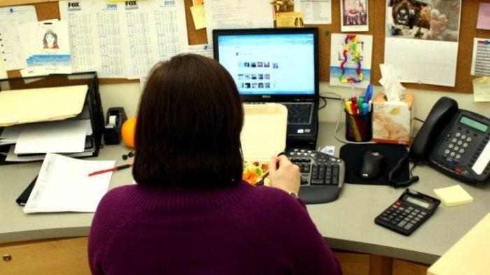 KARYAWAN DIPECAT - Ilustrasi pegawai perempuan saat makan di meja kerjanya di kantor. Hanya karena pulang lebih cepat 1 menit dari jam pulang kantor seorang pegawai perempuan dipecat tiba-tiba oleh perusahaan, tak lama mantan pegawai tersebut justru memenangkan gugatan.