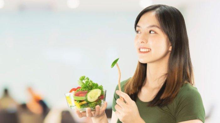 Ilustrasi mengonsumsi salad sayuran untuk menu diet menurunkan berat badan.