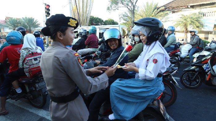 Pengendara motor tertib berlalu lintas dapat apresiasi bunga dan cokelat dari Polwan Polres Gresik, Sabtu (31/8/2024).