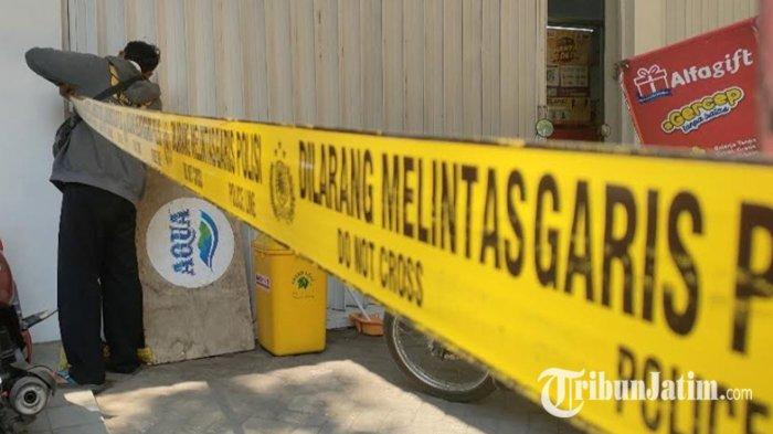 Anggota Polsek Kraksaan saat memasang garis polisi di sekitar alfamart yang jadi sasaran perampokan, Rabu (15/5/2024).