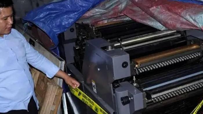 Personel polisi melihat kondisi mesin cetak yang merupakan alat bukti kasus pembuatan dan peredaran uang palsu di Mapolres Kabupaten Gowa, Sulawesi Selatan, Selasa (17/12/2024).
