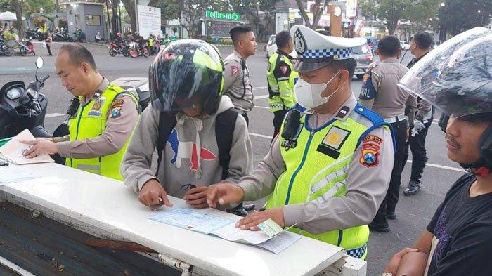 Petugas Satlantas Polresta Malang Kota saat memberikan tindakan tilang manual kepada pelanggar lalu lintas di Jalan Besar Ijen Kota Malang pada Selasa (18/7/2023) lalu.