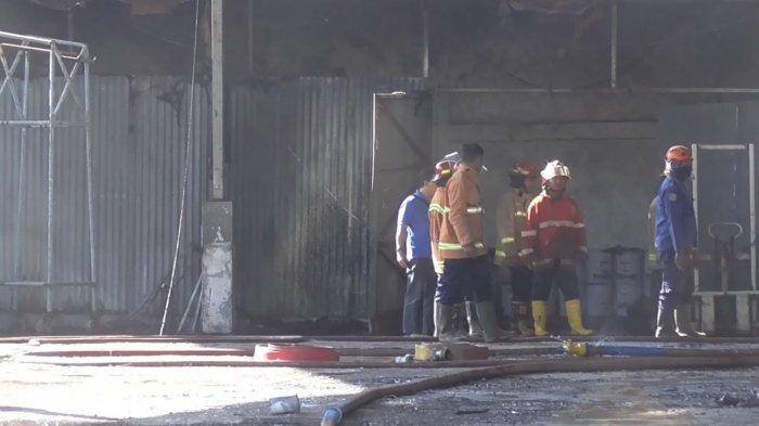 Petugas berupaya memadamkan api yang membara di gudang penyimpanan tiner di Sidoarjo, Rabu (19/7/2023)