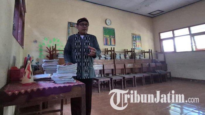 KELAS KOSONG - Plt Kepala SDN Setono, Suhadi saat membereskan ruang kelas II SDN Setono, Jalan Niken Gandini, Kelurahan Setono, Kecamatan Jenangan, Kabupaten Ponorogo, Jatim, Senin (14/7/2025). Lagi, SDN Setono tak dapat siswa baru.