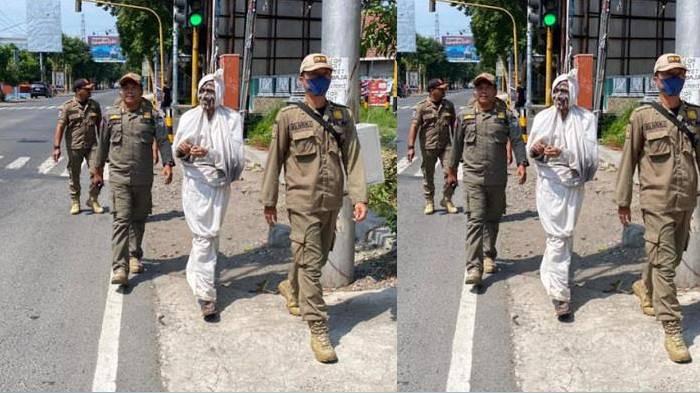 DITERTIBKAN - Seorang pria yang mengenakan kostum pocong diamankan Satuan Polisi Pamong Praja (Satpol PP) saat tengah mengamen di perempatan Paron Kecamatan Ngasem, Kamis (17/7/2025) kemarin.