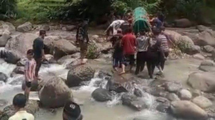 LEWAT SUNGAI - Rombongan pembawa keranda jenazah melintasi sungai di perbatasan Desa Wates dengan Desa Tugurejo Kecamatan Slahung Kabupaten Ponorogo, Jatim, Sabtu (19/4/2025). Viral, sekelompok warga di Ponorogo mengantarkan keranda jenazah melewati sungai.
