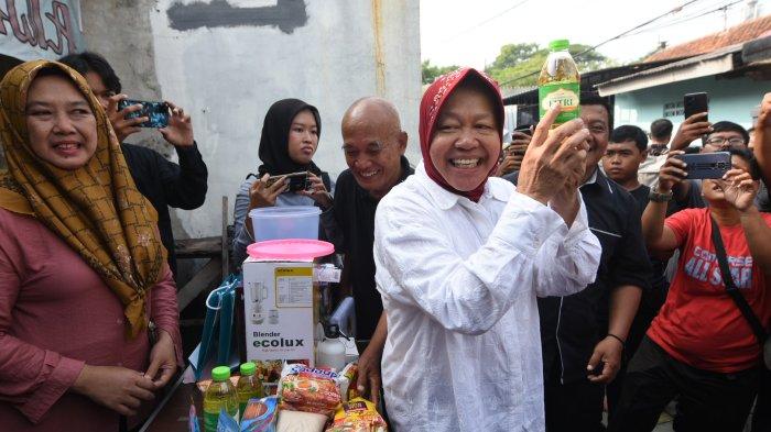 UNDIAN DOOR PRIZE - Calon Gubernur Jatim Tri Rismaharini dapat door prize minyak tanah usai menggunakan hak suaranya di TPS 16 di Wiyung, Rabu (27/11/2024). SURYA/AHMAD ZAIMUL HAQ