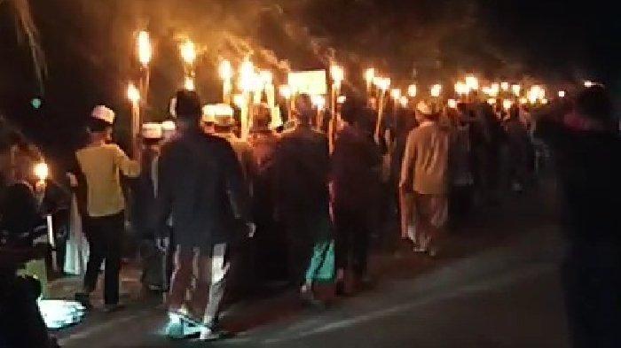 PAWAI OBOR GRESIK - Warga di Desa Indrondelik, Kecamatan Bungah, Kabupaten Gresik mengikuti pawai obor dan takbir keliling menyambut Idulfitri 1446 Hijriyah, Minggu (30/3/2025).