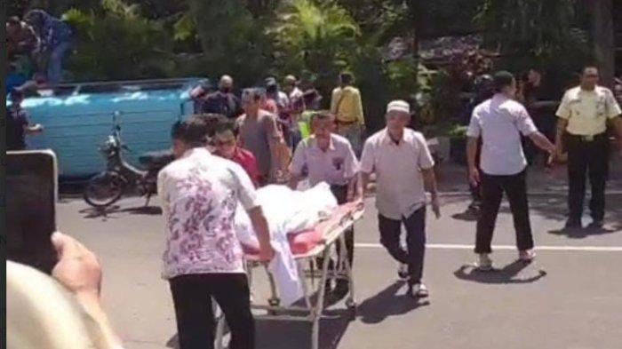AMBULANS TERGULING - Warga evakuasi jenazah dari dalam ambulans di jalan Raya Gajah Mada Jember, Jawa Timur, Selasa (22/4/2025) Mobil Ambulans pengangkut jenazah terguling di Jalan Raya Gajah Mada Jember.