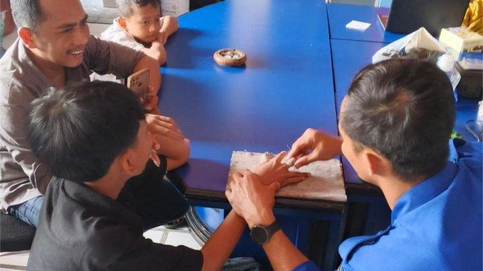 POTONG CINCIN - Anggota Damkar Kabupaten Malang melepaskan cincin yang melingkar di jari Delvin Ardiansyah, Selasa (8/4/2025).
