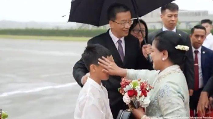 Momen ibu negara Iriana Jokowi mengusap wajah bocah rela kehujanan.