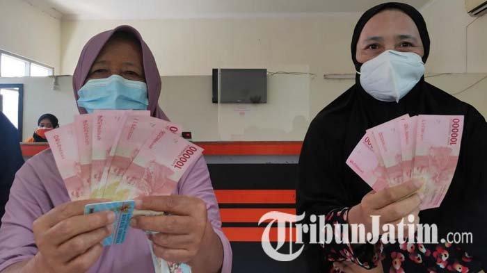 Siti Ngaisah, warga Kauman, Kota Malang, bersama tetangganya usai mengambil bantuan sosial dari pemerintah pusat di Kantor Pos Malang, Rabu (21/7/2021).