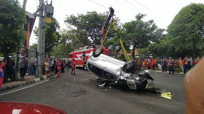 EVAKUASI KECELAKAAN - Kondisi Mobil Toyota Avanza terbalik dan sedang dievakuasi; pembalikan ulang menggunakan truk crane Tim Rescue Dinas Pemadam Kebakaran dan Penyelamatan (DPKP) Surabaya di Jalan Kusuma Bangsa, Surabaya, pada selasa (22/4/2025) siang