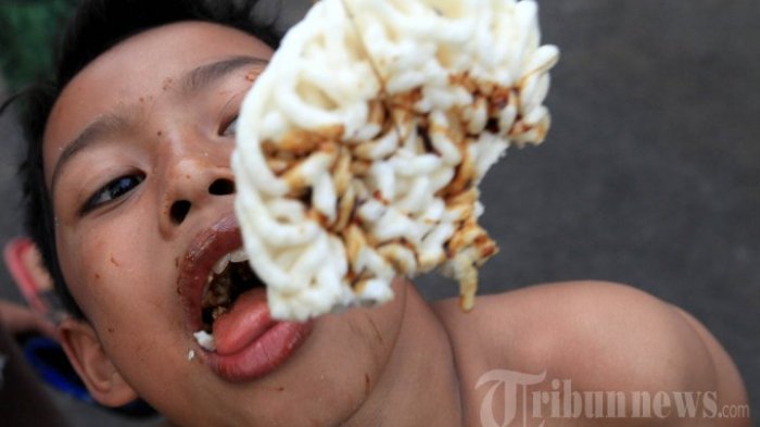 Bocah mengikuti lomba makan kerupuk yang diselenggarakan Karang Taruna RW 05, Kelurahan Braga, Jalan Lembong, Kota Bandung, Minggu (9/8). Kegiatan ini merupakan rangkaian peringatan HUT ke-70 Republik Indonesia di RW tersebut yang puncaknya akan berlangsung pada 17 Agustus 2015.