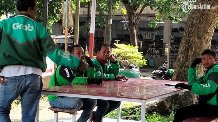 LELAH - Salah satu pengendara ojek online saat menepi di depan City of Tomorrow (Cito) Mal Bundaran Waru Surabaya, Kamis (7/5/2025) petang. Sebanyak 16.000 pengemudi ojek online akan diikutkan BPJS Ketenagakerjaan oleh Pemkot Surabaya.