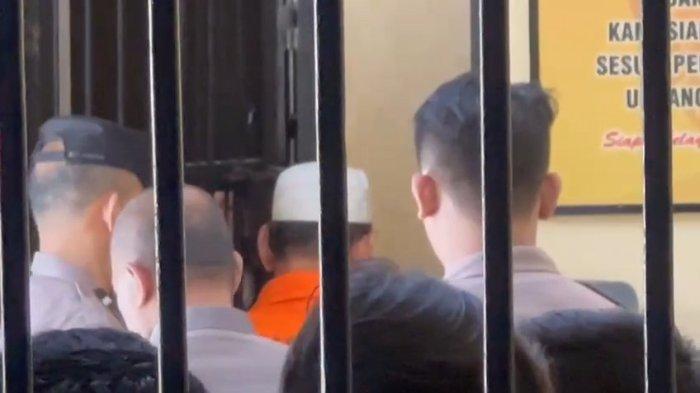 DITAHAN - Tersangka kasus pelecehan terhadap santri sendiri, inisial AUR (rompi tahanan orange), dijebloskan ke tahanan Mapolres Ngawi, Rabu (26/3/2025). AUR yang merupakan pengasuh pondok pesantren diduga melecehkan santri dibawah umur.